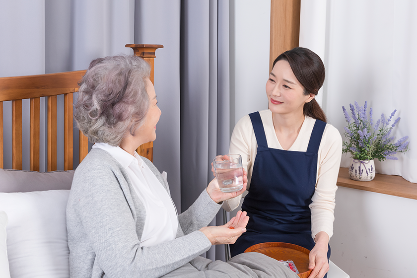 Asian caregiver and old woman at nursing home